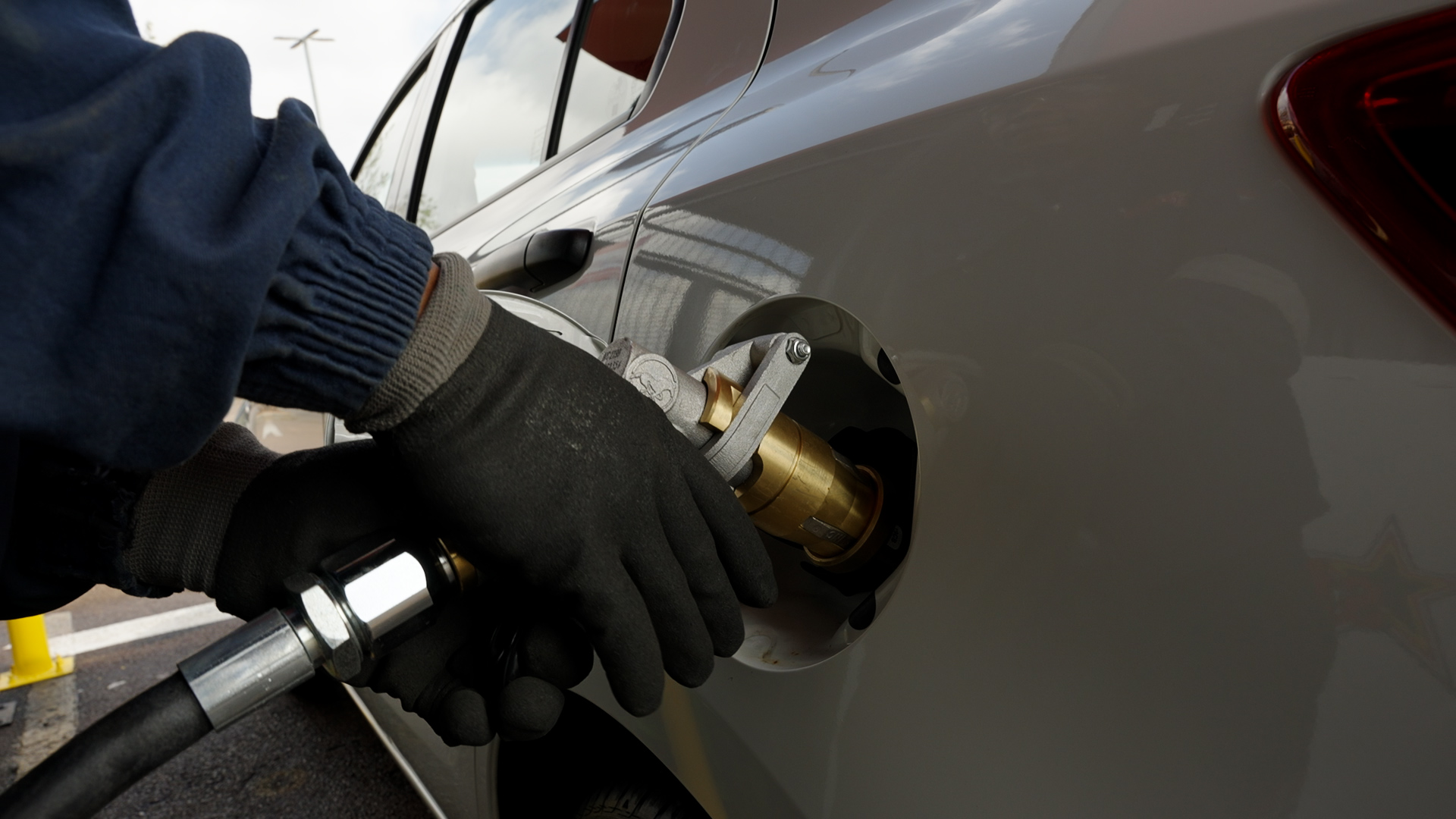 Gloved hand filling a car with Autogas from an LPG nozzle